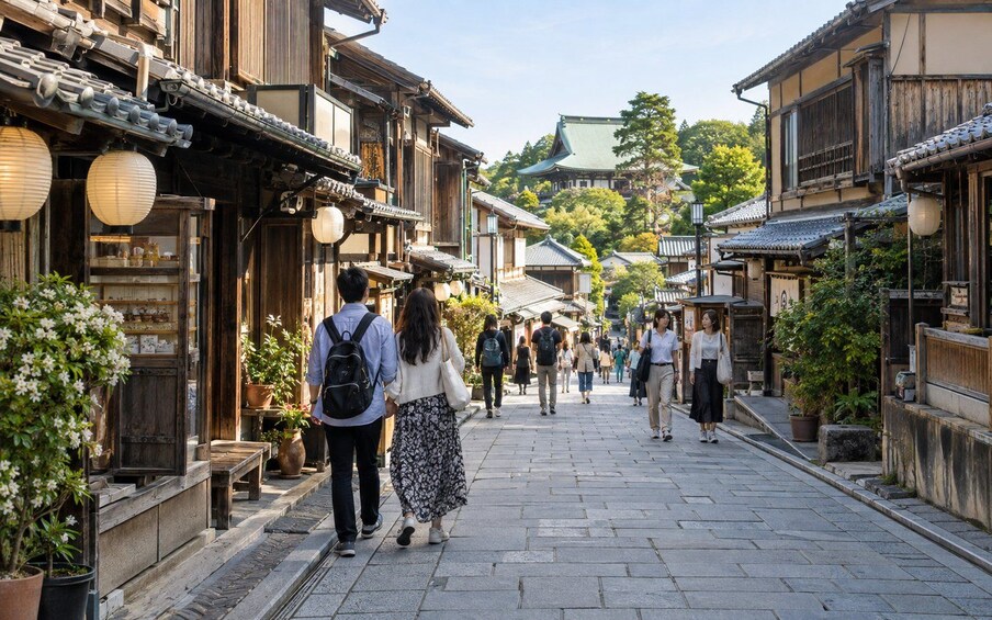 Una calle tradicional japonesa con edificios de madera, faroles y transeúntes. 5