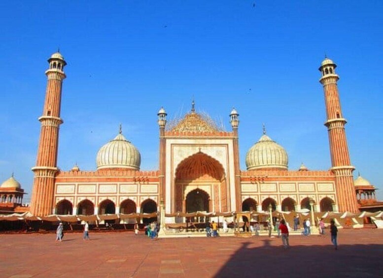En stor moské med flere kupler og minareter, en rummelig gårdsplads og folk, der går rundt. 1