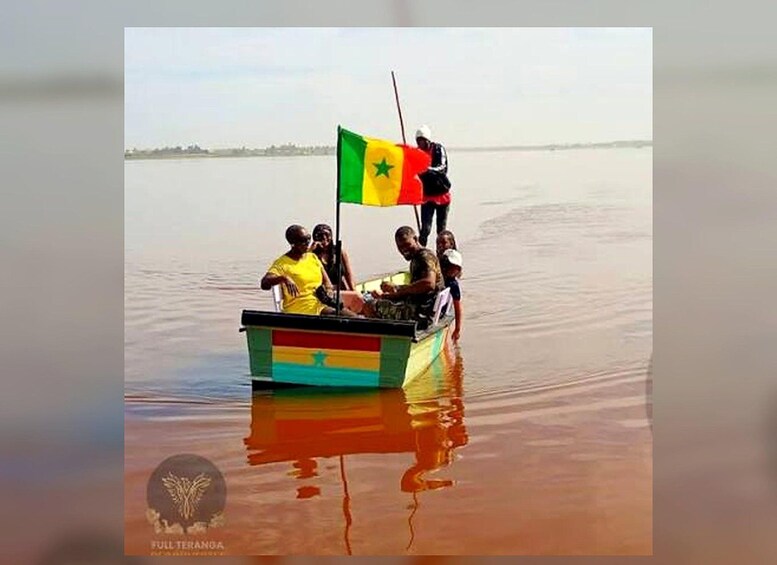 A boat with people on a calm body of water, a flag, and a logo at the bottom. 3