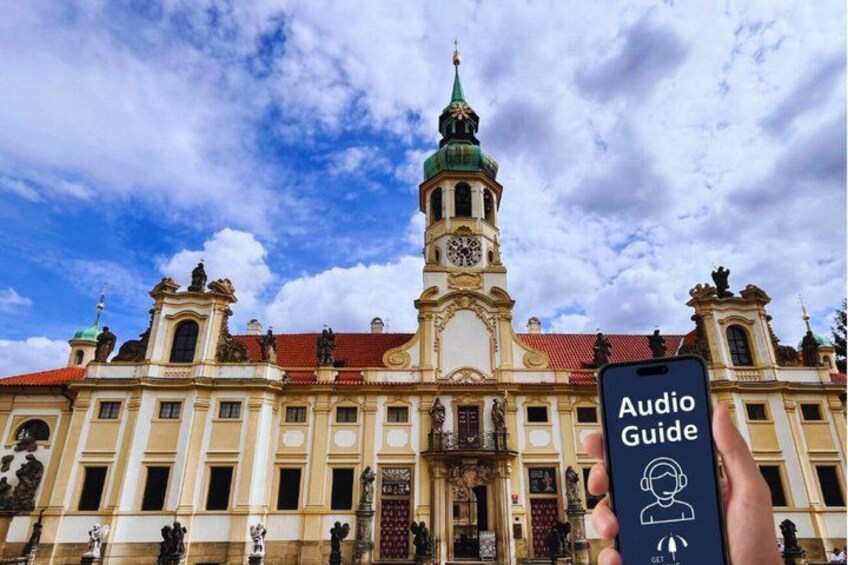 A historic building with a clock tower, statues, and a person holding a smartphone with an audio guide icon. 1