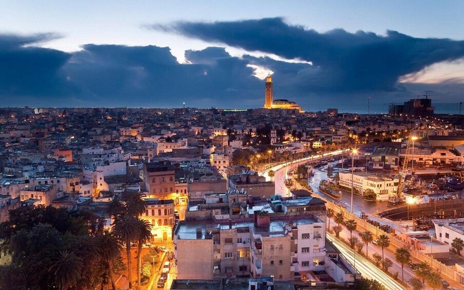 A cityscape at dusk with a prominent tower and a mosque. 4