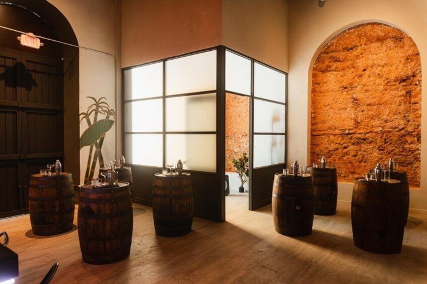 A room with wooden barrels, a large window, and a brick wall. 5