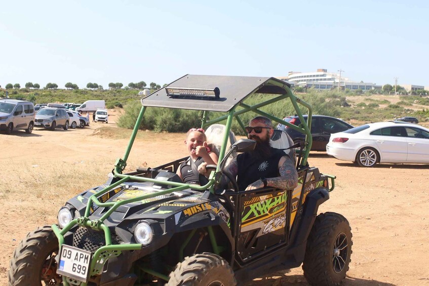 A green off-road vehicle with a license plate on a dirt road. 4