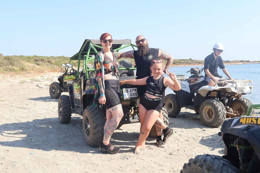 A group of people on a sandy beach with ATVs and a green off-road vehicle. 5