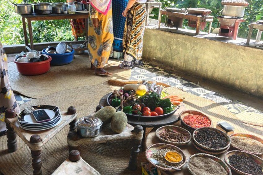A traditional outdoor setting with a variety of food items and cooking utensils. 4