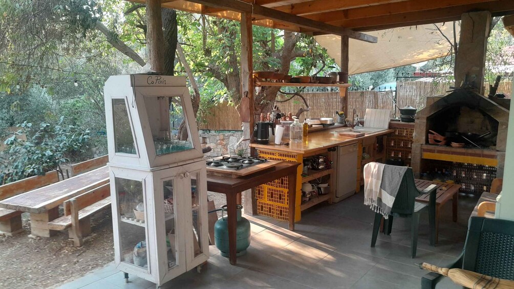 Cocina exterior con parrilla, zona de preparación de alimentos y asientos. 2