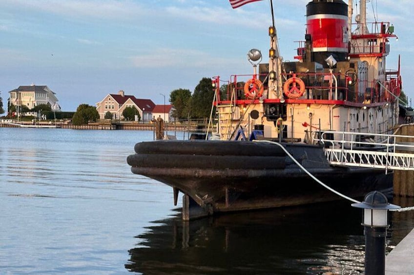 A large ship docked at a pier with a lifeboat and American flag. 3