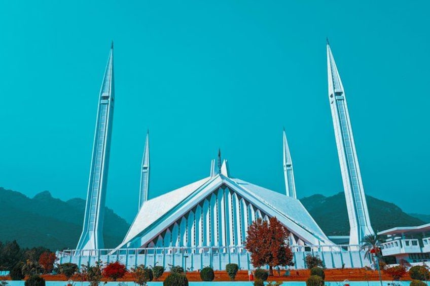 A modern architectural structure with a central dome and four tall spires. 2