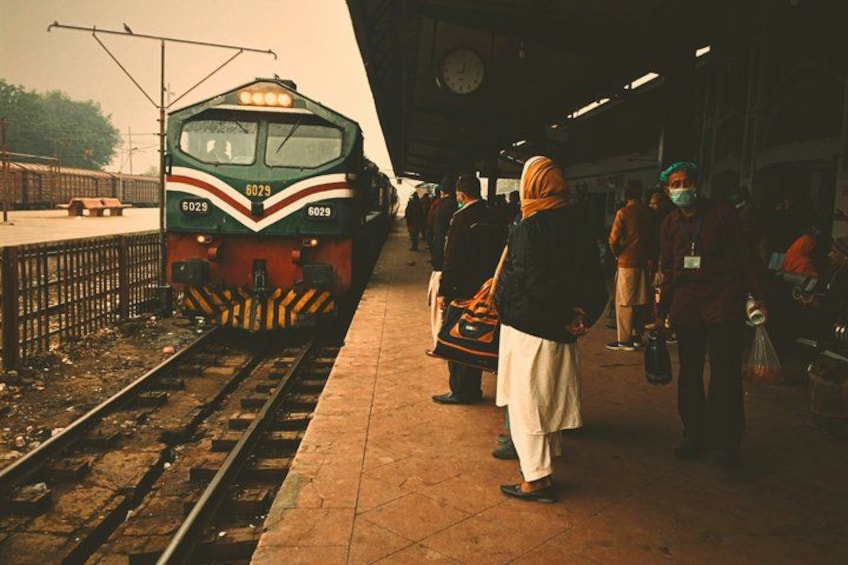 A train at a station with passengers waiting. 4