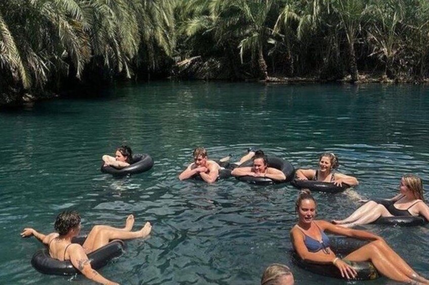 People floating on water in a natural setting with dense vegetation. 1
