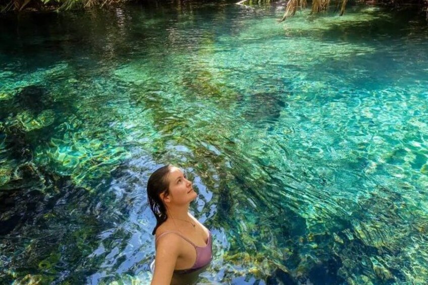 A woman in a swimsuit standing in clear water. 4