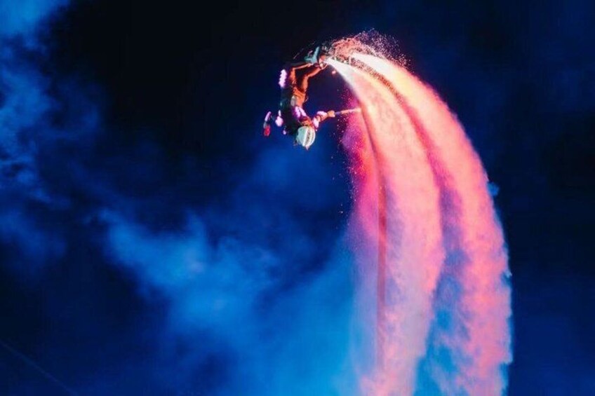 A person performing a water stunt with a jetpack, creating a spray of water. 1