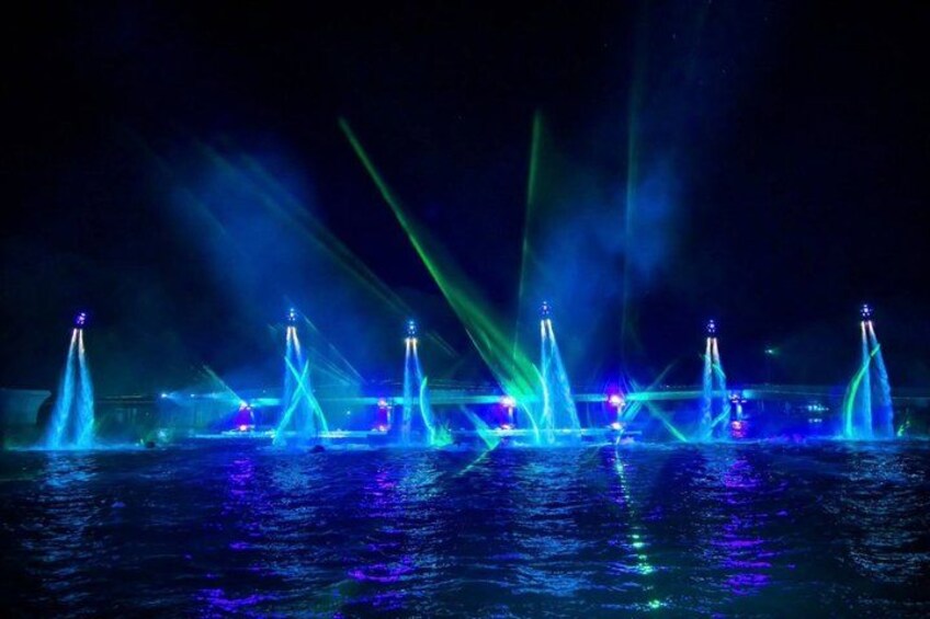A nighttime water fountain show with illuminated jets and beams. 5