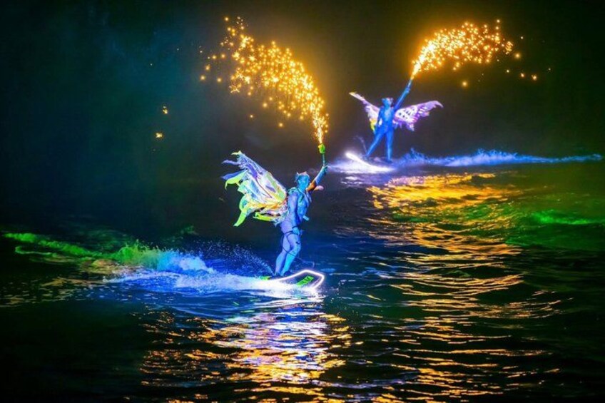 A person performing water-based acrobatics with fireworks in the background. 2