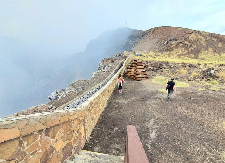 A rocky path with a stone wall on one side and a wooden structure on the other. 3