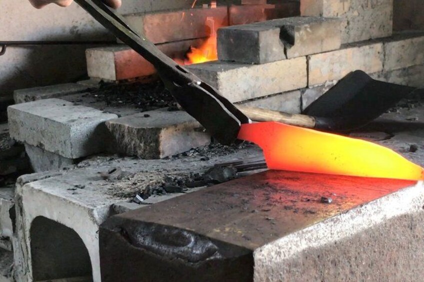 A forge with a glowing fire, anvil, and tongs. 2