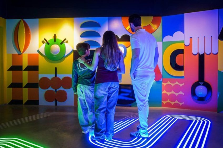 A colorful mural with abstract shapes and a neon-lit floor. 1
