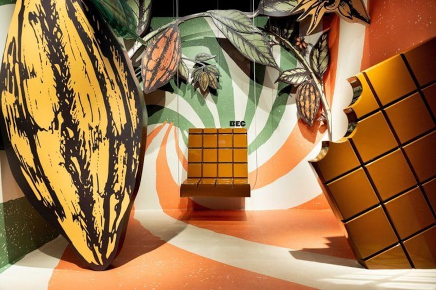 A display with a large yellow banana, a chocolate bar, and a decorative background with leaves and a striped pattern. 3