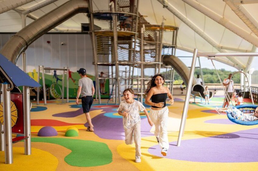 A playground with colorful play structures and a slide. 2