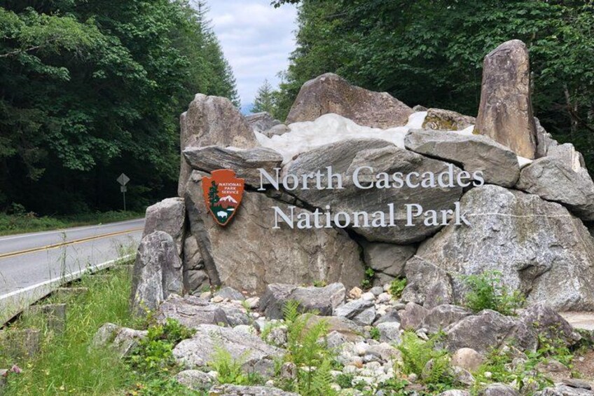 A rocky terrain with a sign for North Cascades National Park. 1