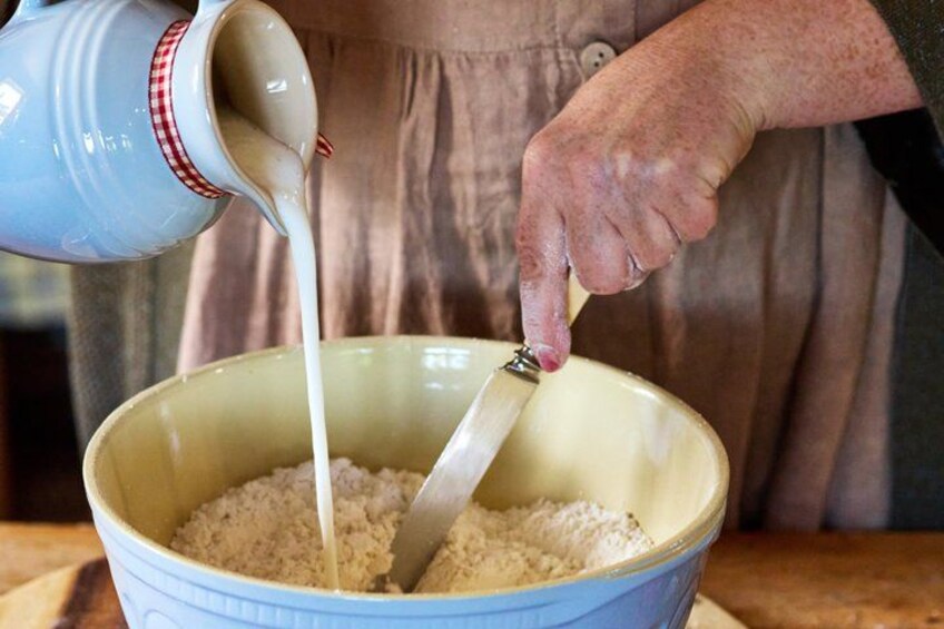 A person pouring milk into a bowl of rice. 2