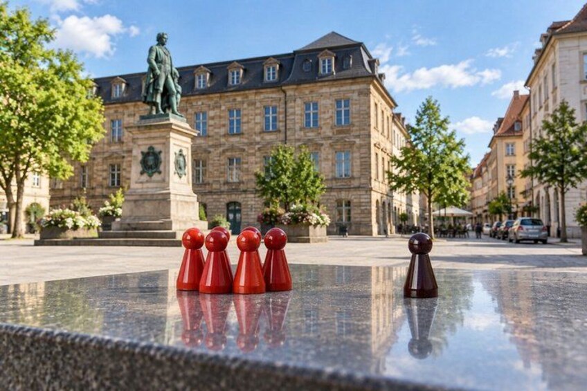 A chessboard with pieces in front of a historic building with a statue. 4
