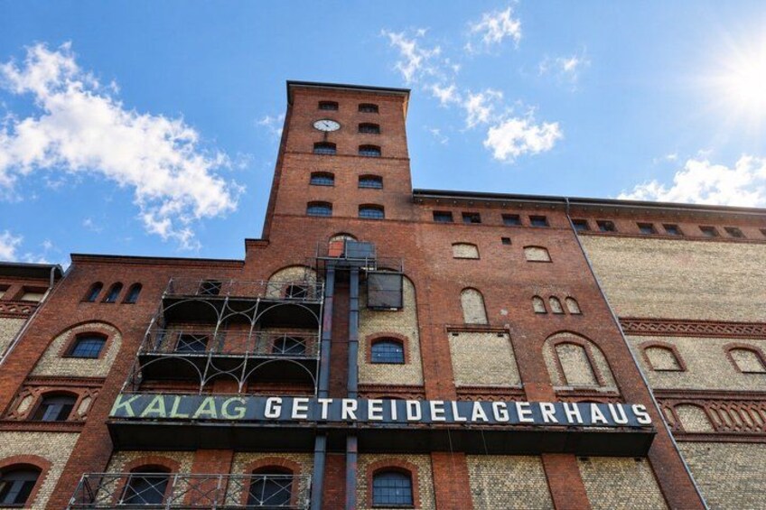A red brick building with the sign 'KALAG GETREIDELAGERHAUS' and a clock on the tower. 5