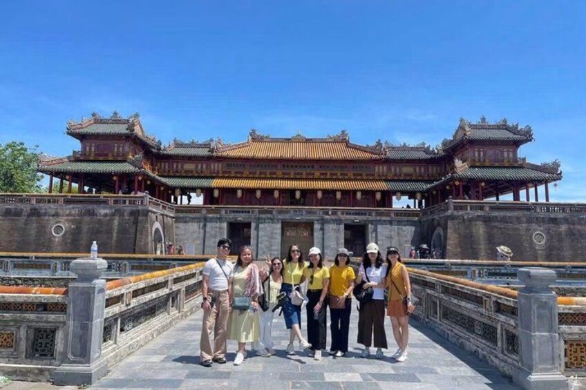 A group of people standing in front of a traditional Chinese building with ornate architecture. 4