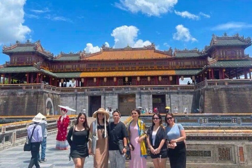 A group of people standing in front of a traditional Chinese building with ornate architecture. 2