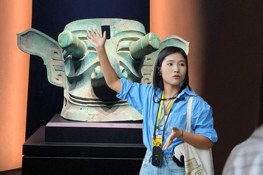 A person taking a photo of a large bronze sculpture. 1