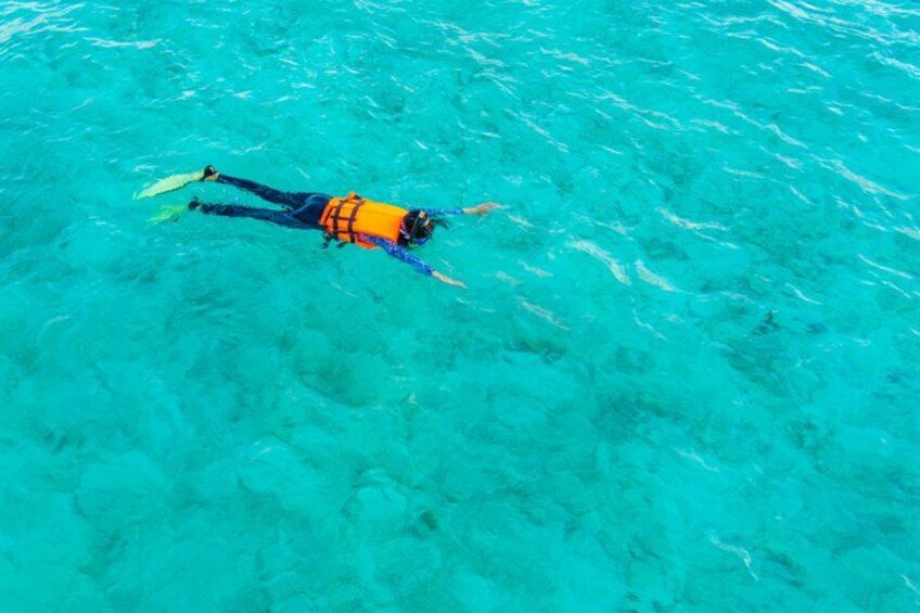 A person snorkeling in clear turquoise water. 3