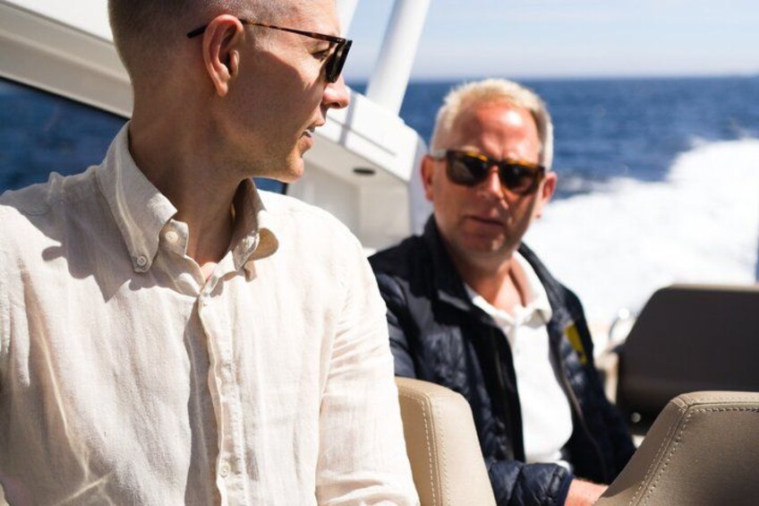 Twee mensen in een boot, met de oceaan op de achtergrond. 4
