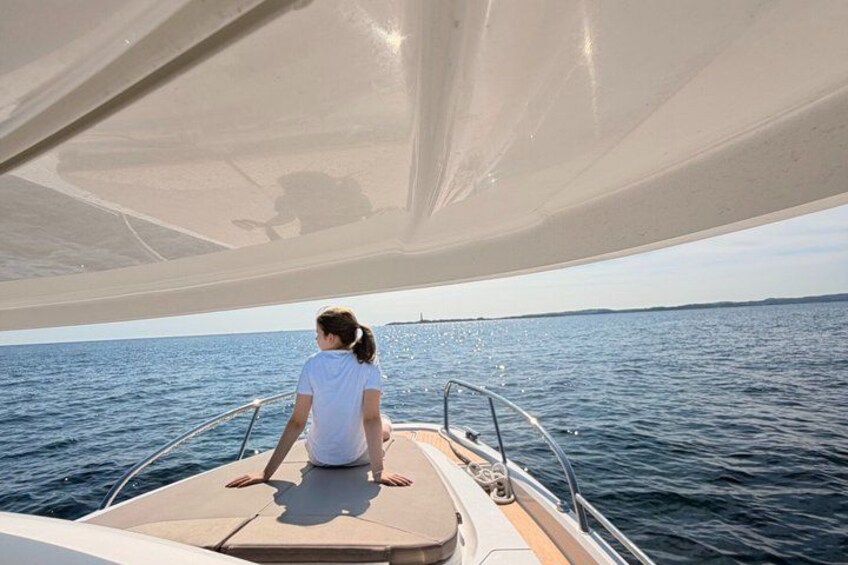 Iemand zit op een boot met een zeil erboven, op het water. 1
