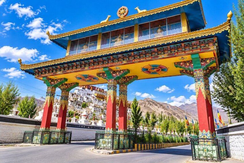 A colorful traditional Tibetan gate with intricate designs and a clear blue sky in the background. 1