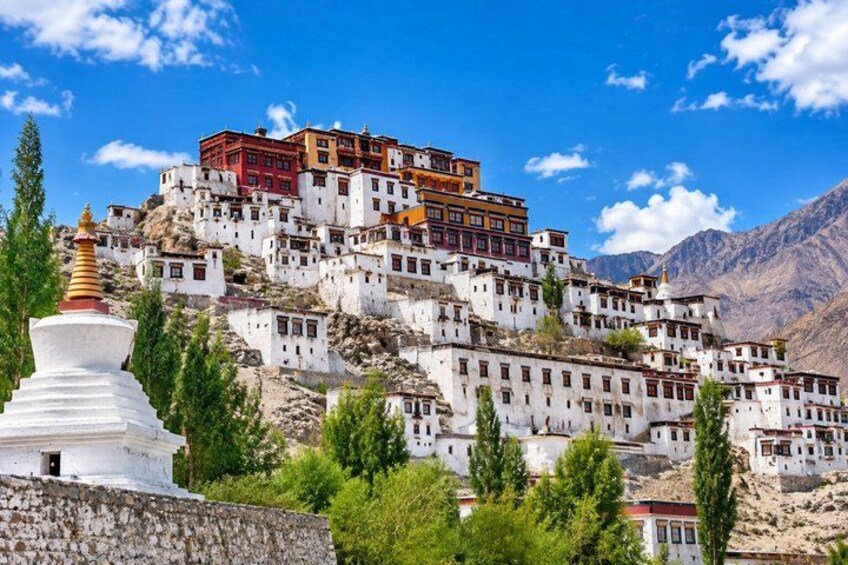 A monastery complex on a hillside with white buildings and a red-roofed structure. 5