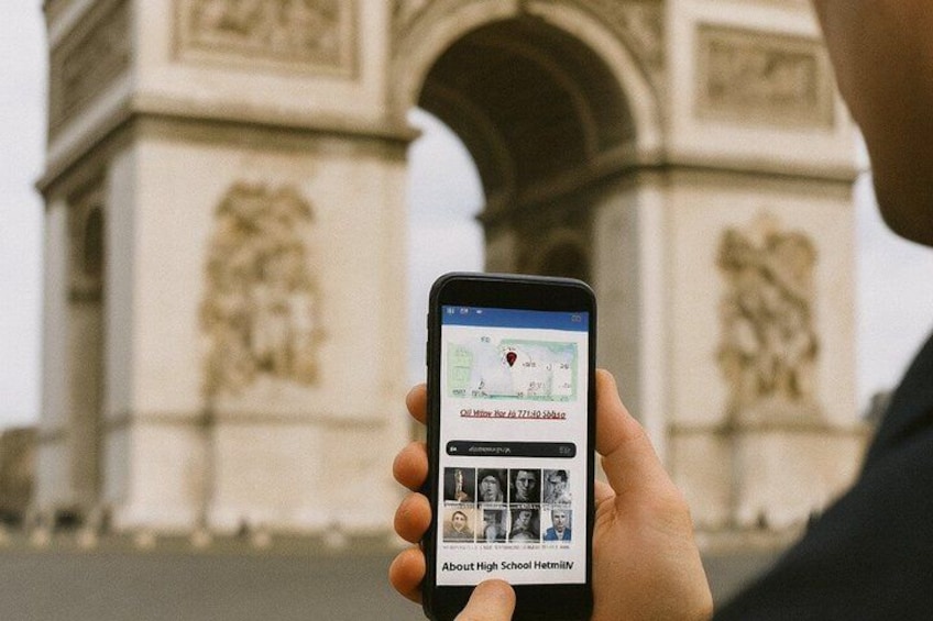 A person holding a smartphone with a map application, standing in front of the Arc de Triomphe in Paris. 4