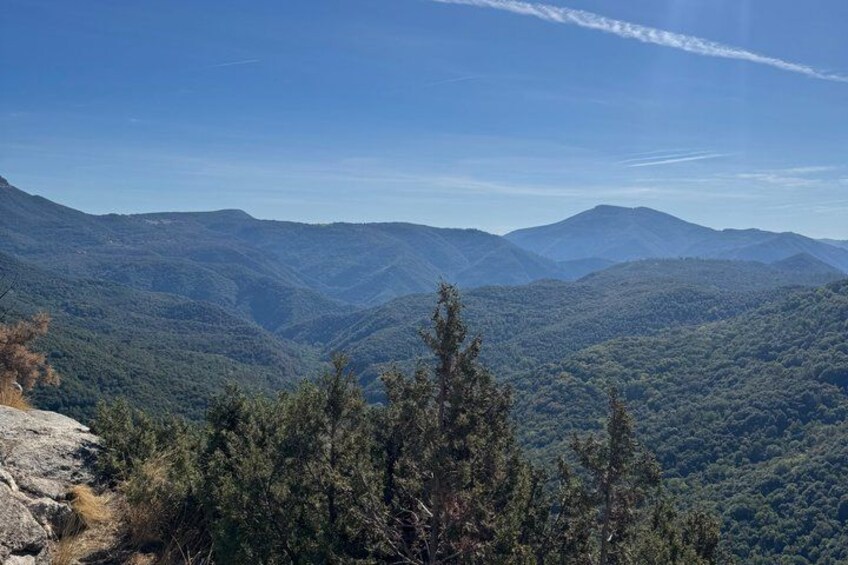 A mountainous landscape with dense forests and a clear sky. 2