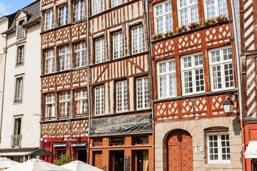 A row of half-timbered buildings with arched doorways and windows. 2