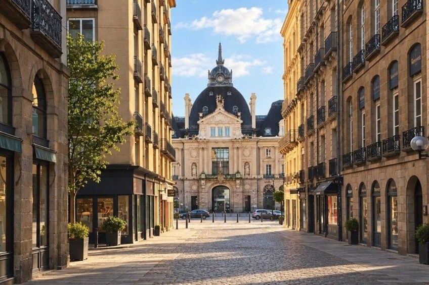 A cobblestone street with historic buildings, a prominent dome, and a clear sky. 4