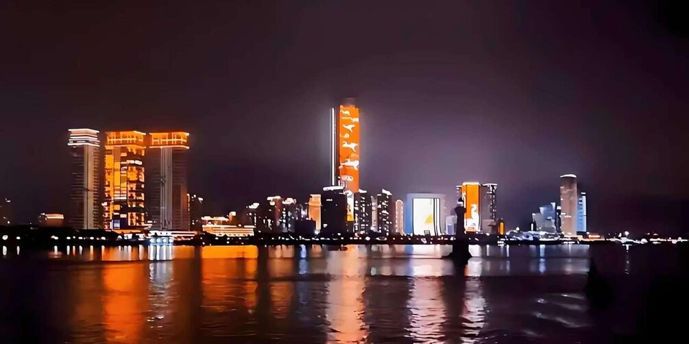 A nighttime cityscape with illuminated buildings reflecting on the water. 4