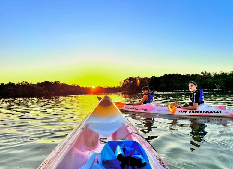 Deux kayaks sur une eau calme, avec un coucher de soleil en arrière-plan. 5