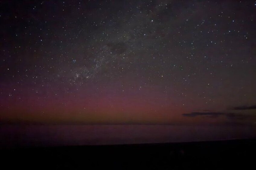 A night sky with stars and a pinkish horizon. 1