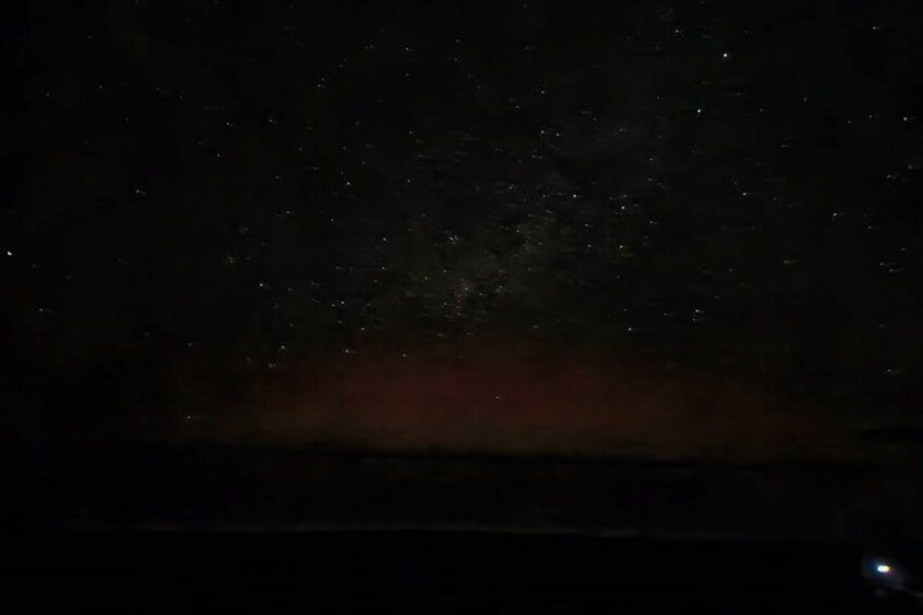 A night sky with stars and a faint red glow near the horizon. 4