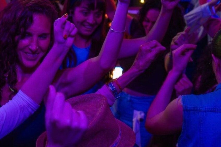 A group of people dancing in a dimly lit setting. 2