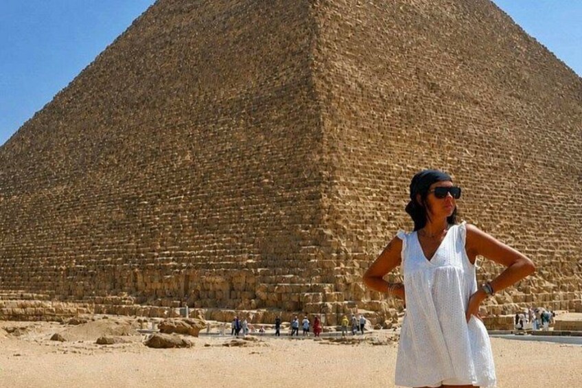 A large pyramid structure with a person standing in front of it. 2