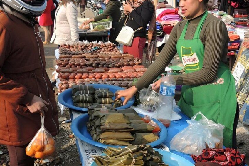 A market stall with various food items, including wrapped goods and fresh produce. 3