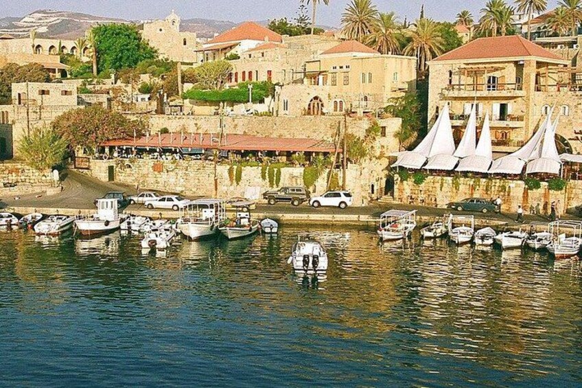 A harbor with boats, buildings, and a waterfront restaurant. 1