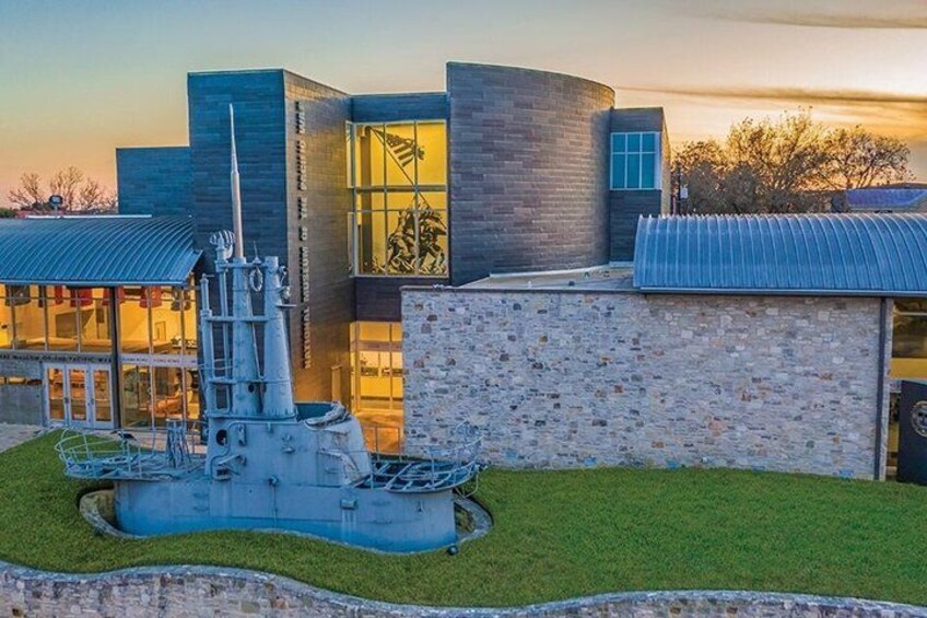 A modern building with a large ship sculpture in front. 1