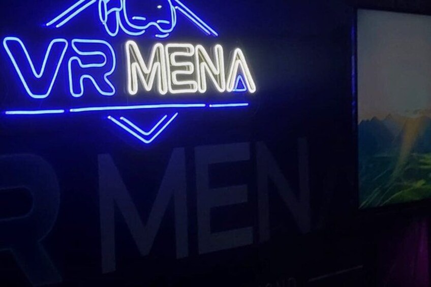 A neon sign with the text 'VR MENA' and a partial view of a mountain landscape. 5