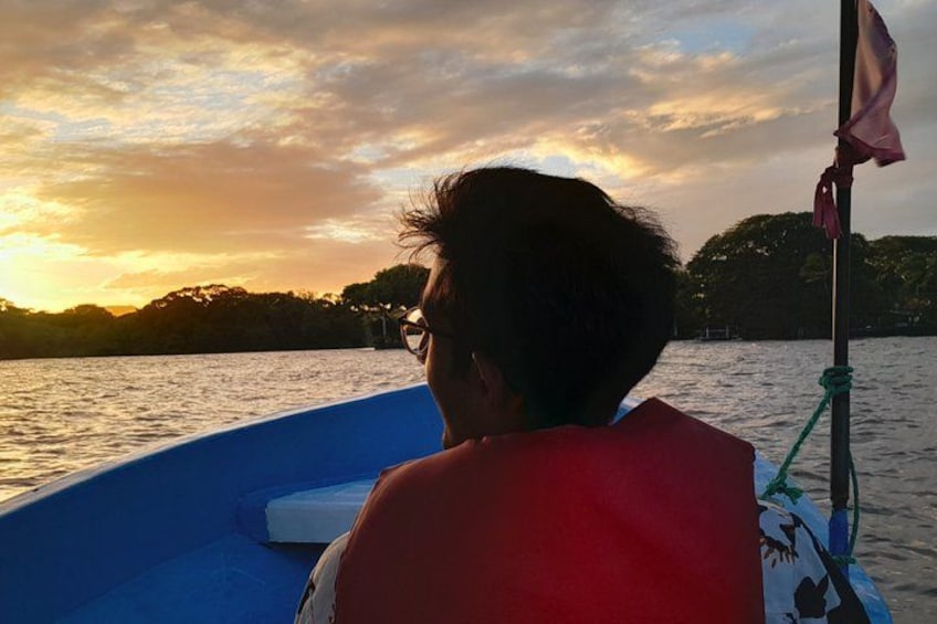 A person on a boat with a sunset in the background. 1